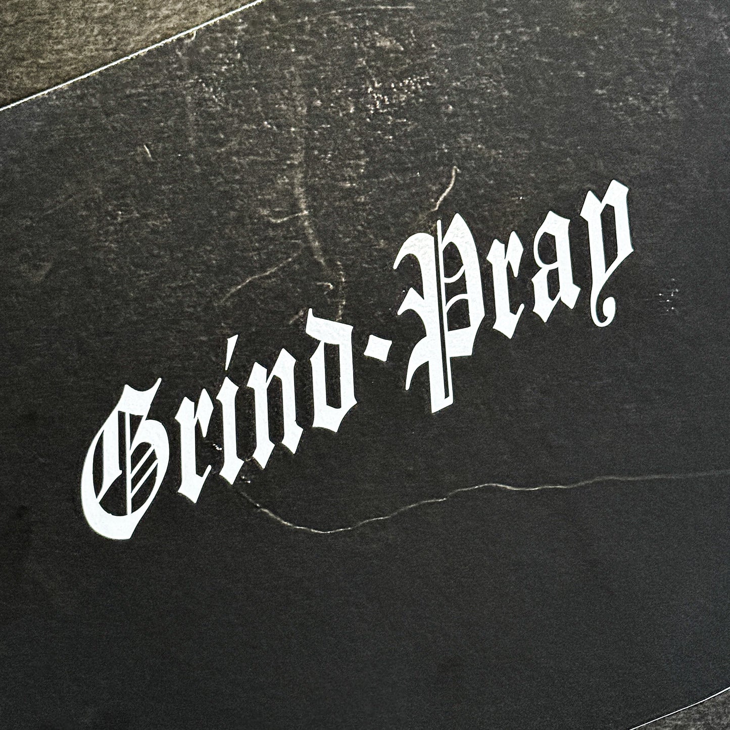 Grind and Pray die-cut vinyl sticker in gloss white by Streetfuel